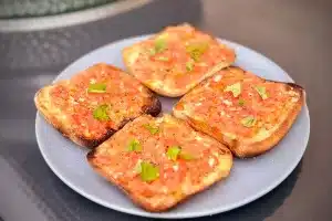 Picture of plate of Pane Con Tomate next to a bbq